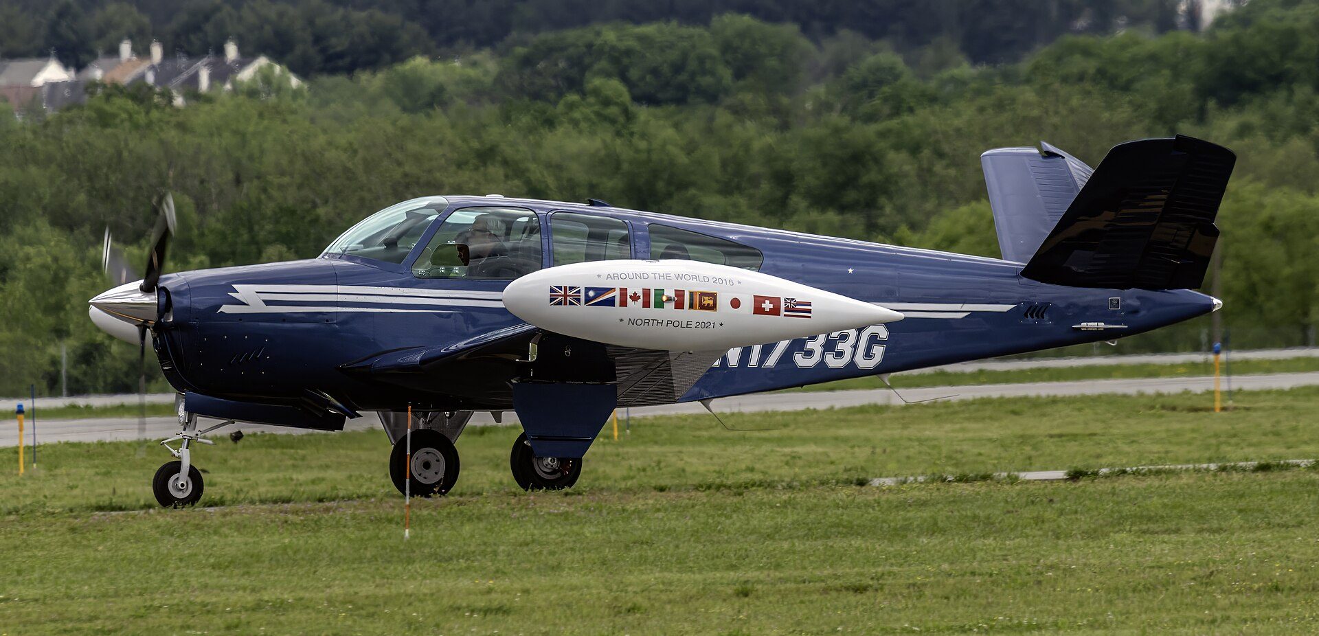 Single-engine airplane taxiing on a grass-lined taxiway