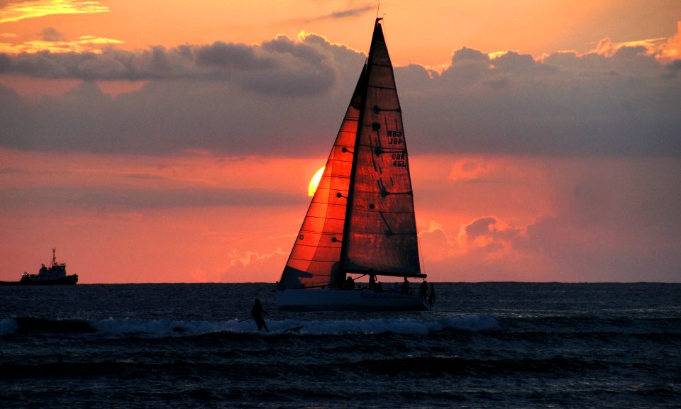Sailboat silhouetted against a red sunset
